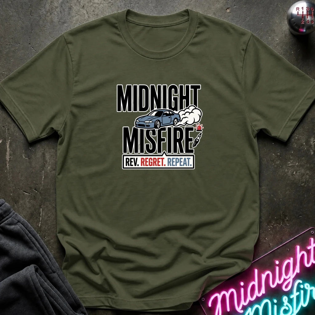 An olive green short-sleeve t-shirt with a graphic print reading 'MIDNIGHT MISFIRE' and 'REV. REGRET.