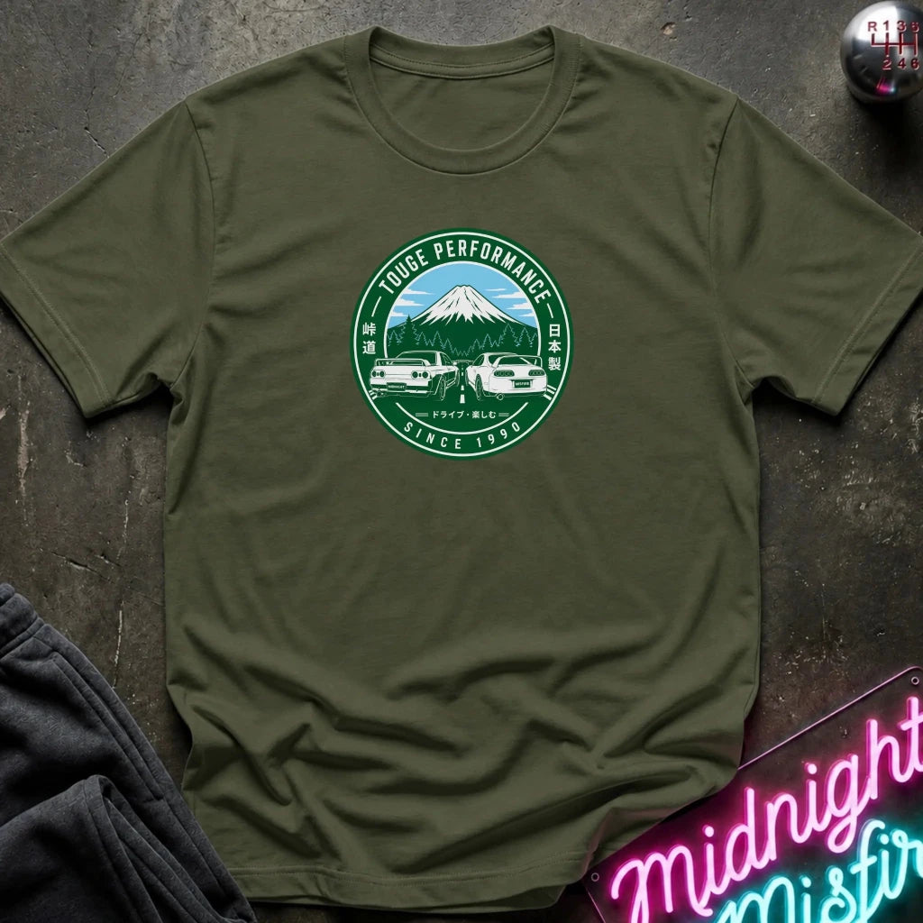 An olive green crewneck t-shirt with a circular logo and 2 white cars