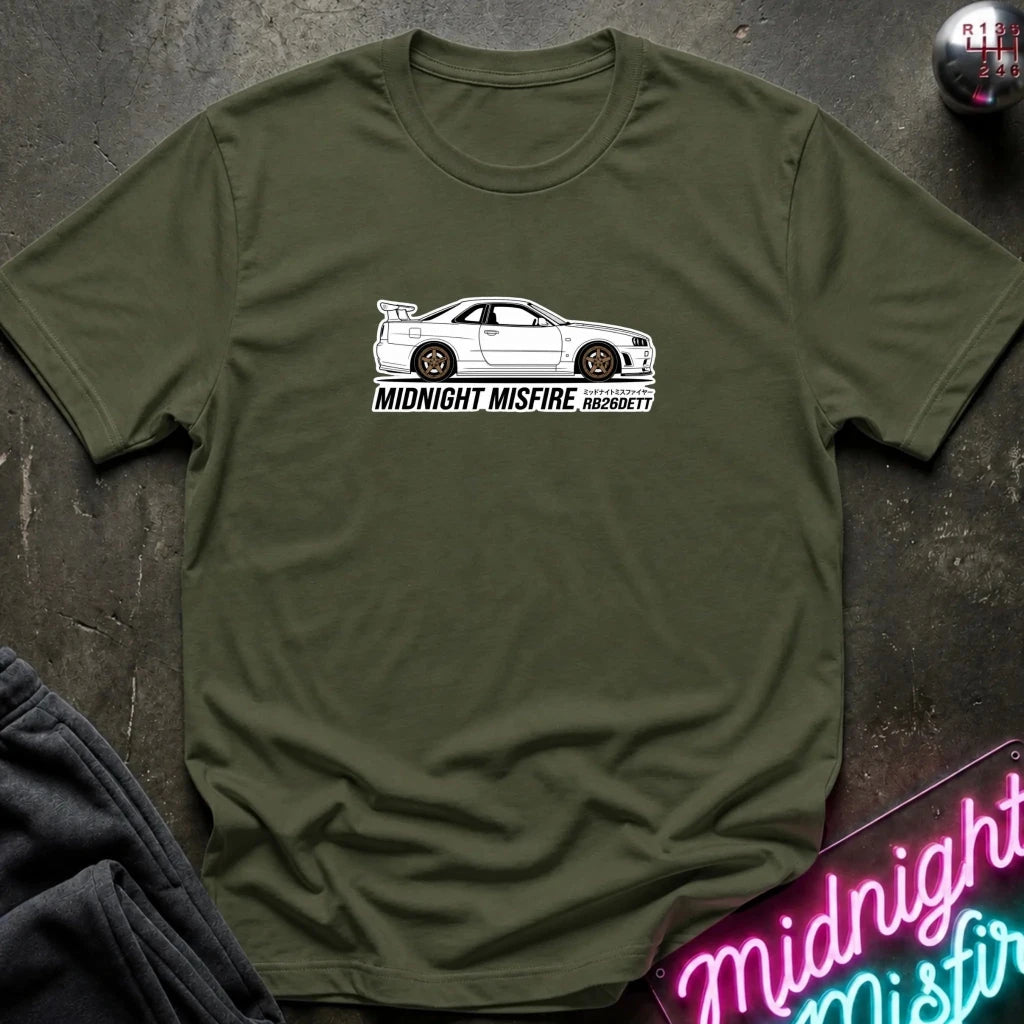 olive short-sleeve t-shirt laid flat on a dark textured surface, featuring a white sports car graphic and the text 'MIDNIGHT MISFIRE '