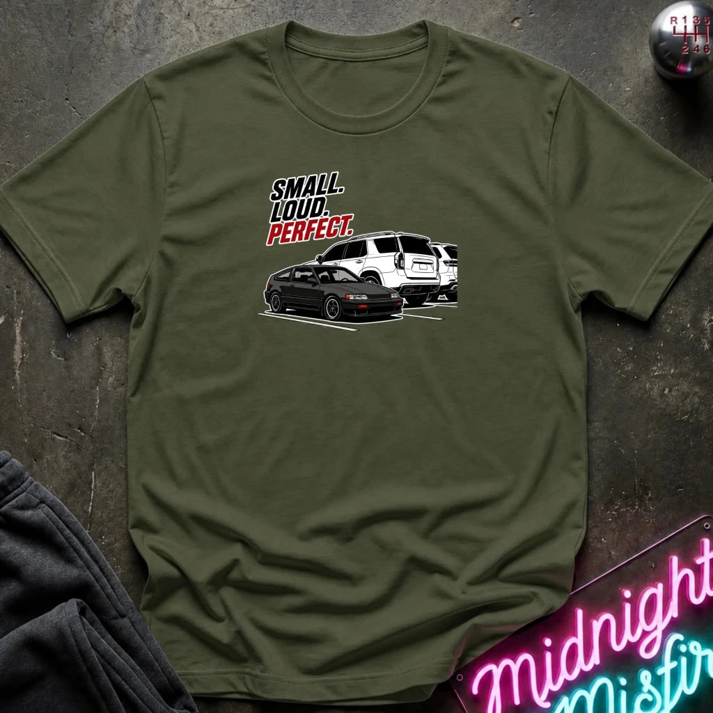 olive green   short-sleeve graphic t-shirt laid flat on a dark textured surface. The graphic features the text 'SMALL louD PERFECT.