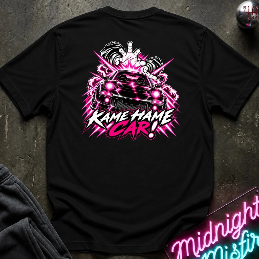 black short-sleeve t-shirt laid flat on a dark textured surface, featuring a large graphic print of a black sports car with  the text 'KAME HAME CAR!' 