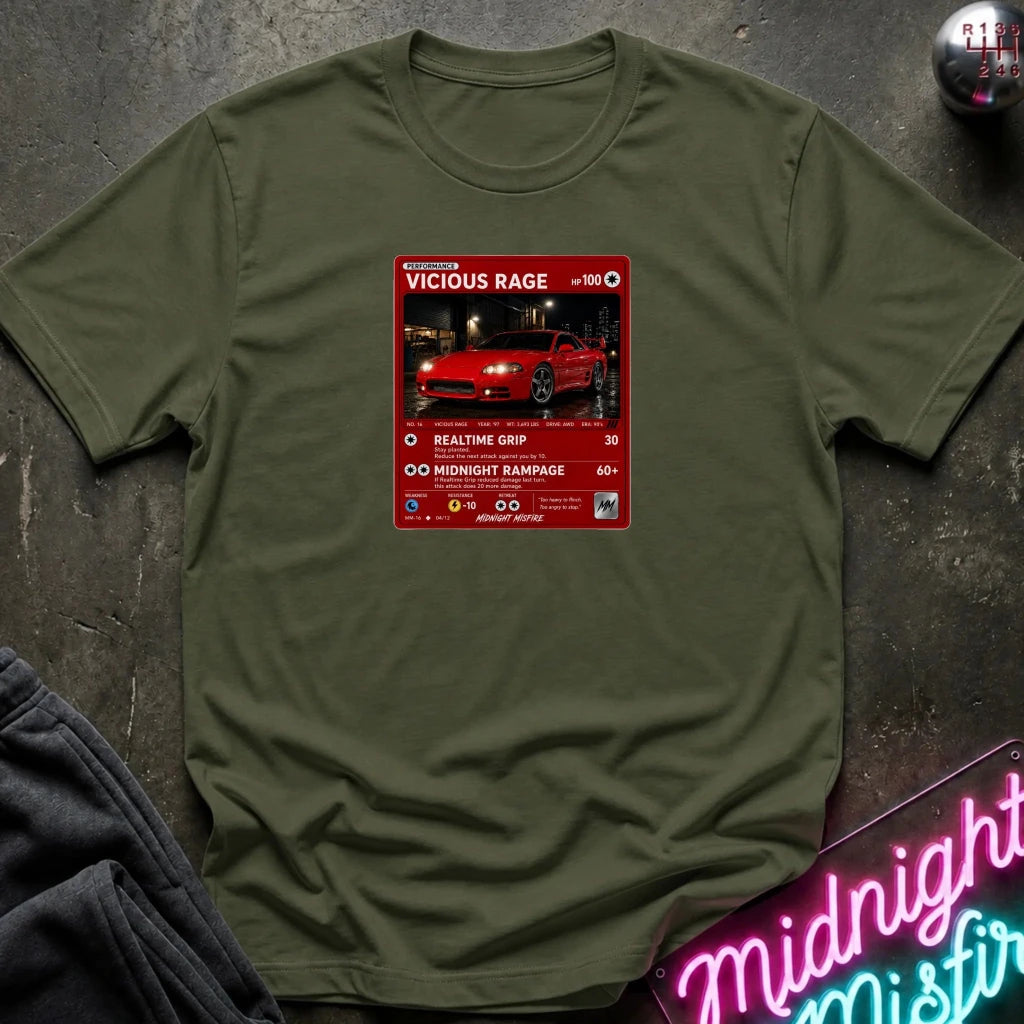 green crewneck t-shirt laid flat on a dark textured surface. The shirt features a red rectangular graphic print in the center with a red sports car 