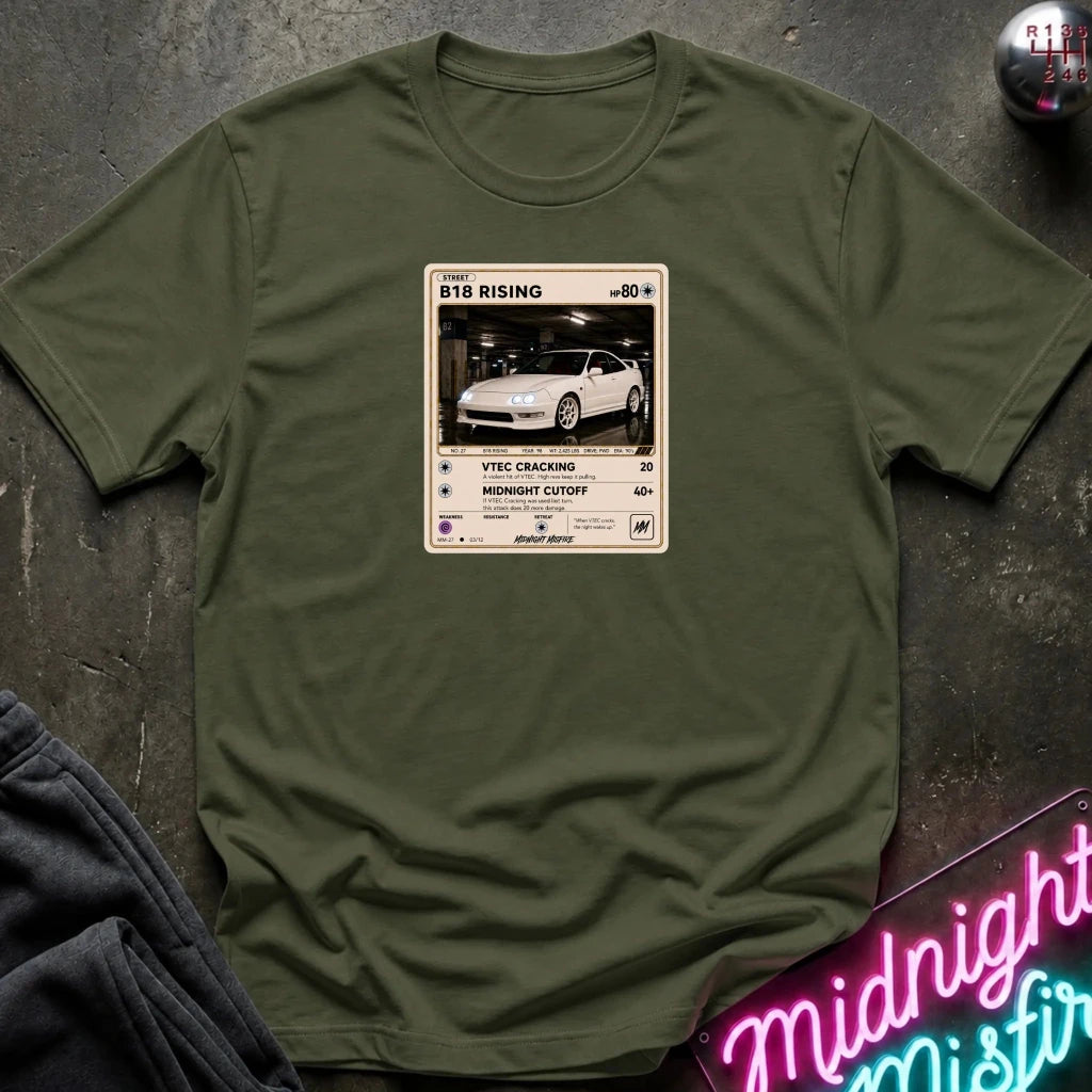 olive green crewneck t-shirt laid flat on a dark textured surface. The shirt features a graphic print styled like a retro card