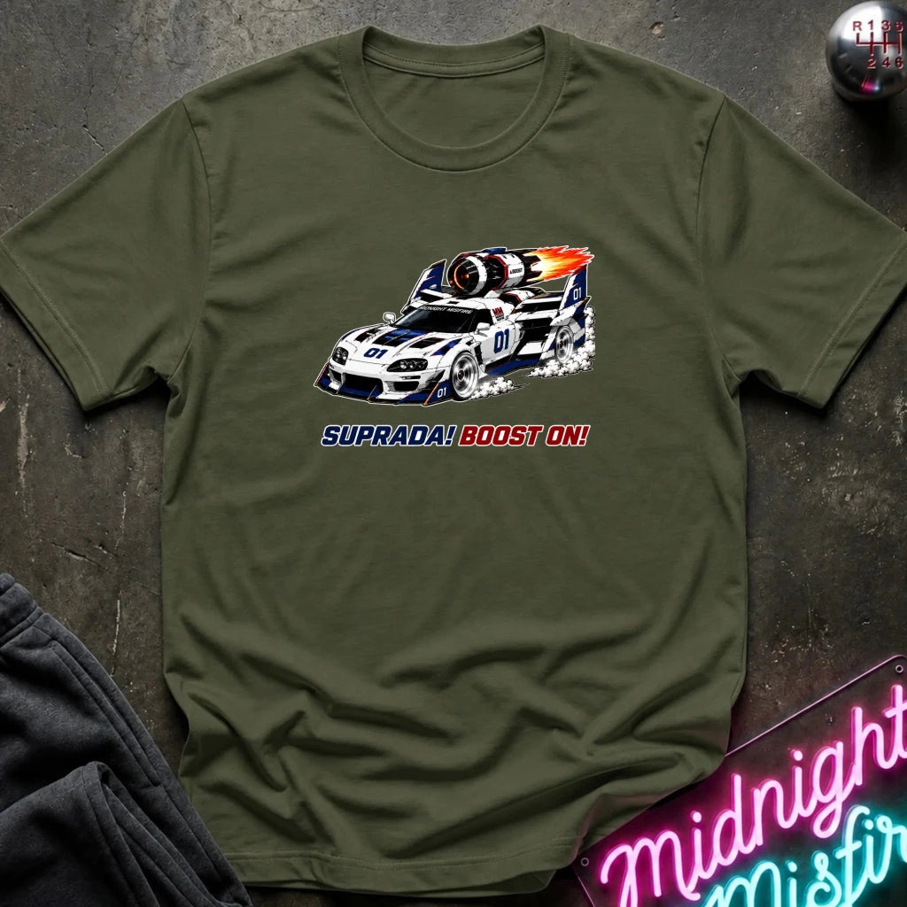 An olive green crewneck t-shirt featuring a graphic of a white and blue race car with flames and the text 'SUPRADA! BOOST ON!' printed on the front, laid flat on a dark textured surface.