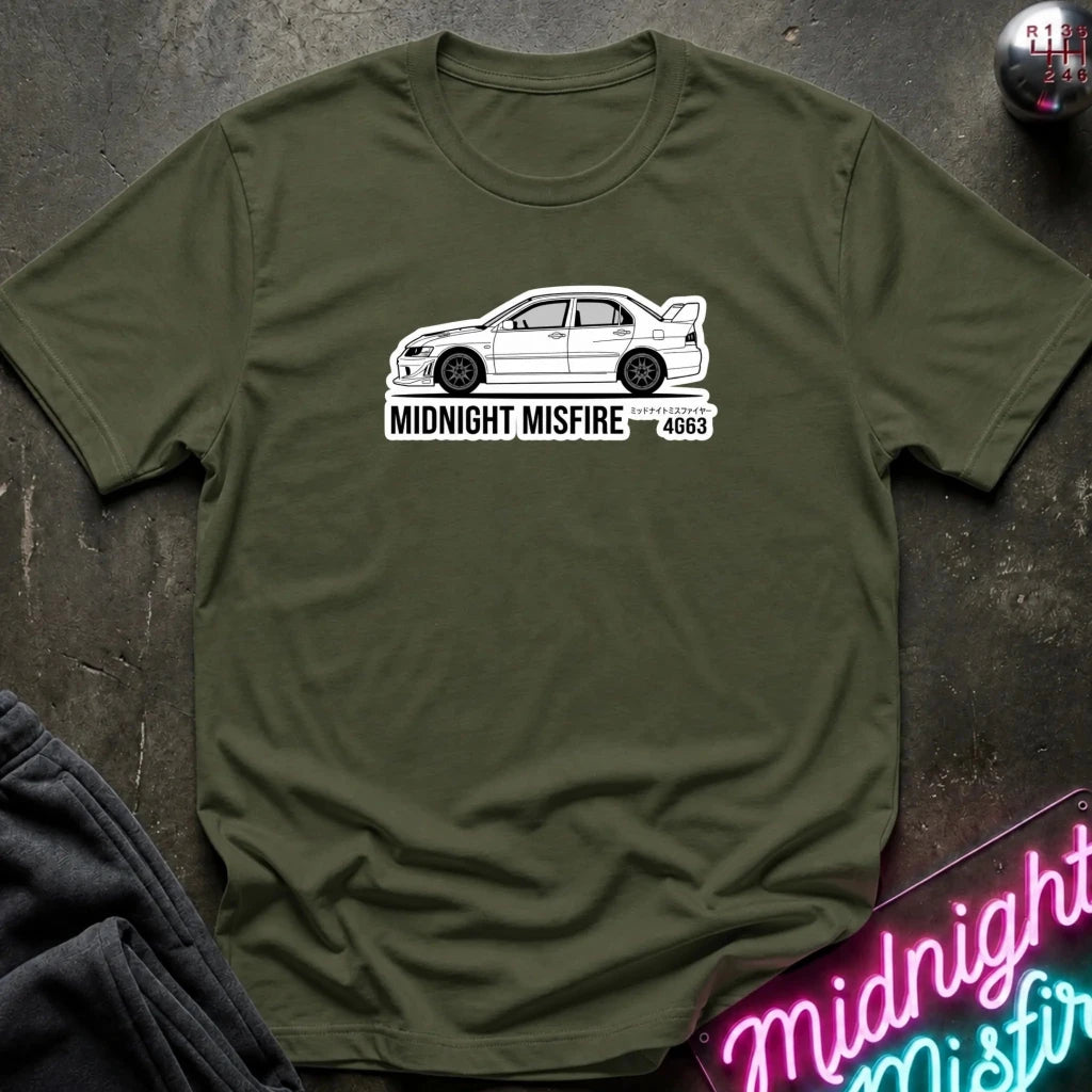 olive short-sleeve t-shirt laid flat on a dark textured surface, featuring a white sports car graphic and the text 'MIDNIGHT MISFIRE '