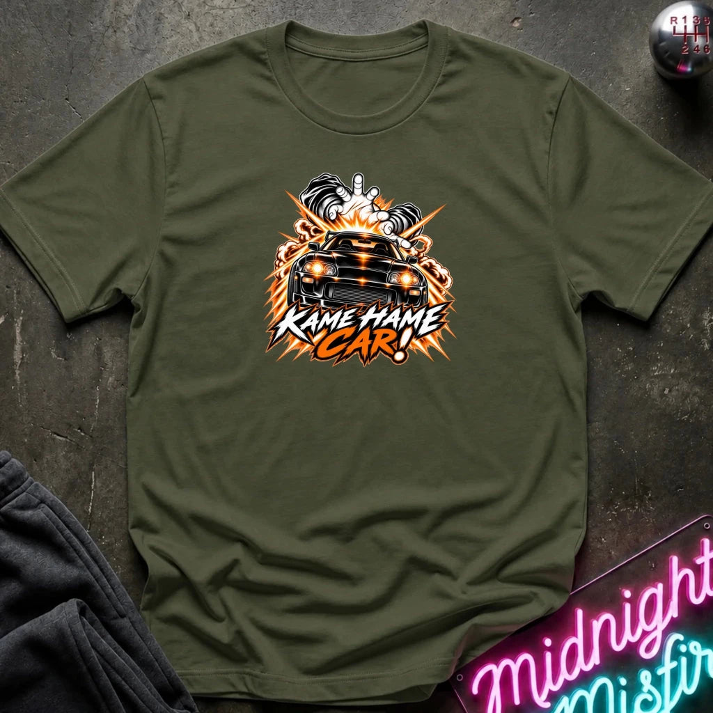 olive short-sleeve graphic t-shirt laid flat on a dark textured surface. The shirt features a red, white, and black graphic of a car with the text 'KAME HAME CAR!' in stylized lettering.
