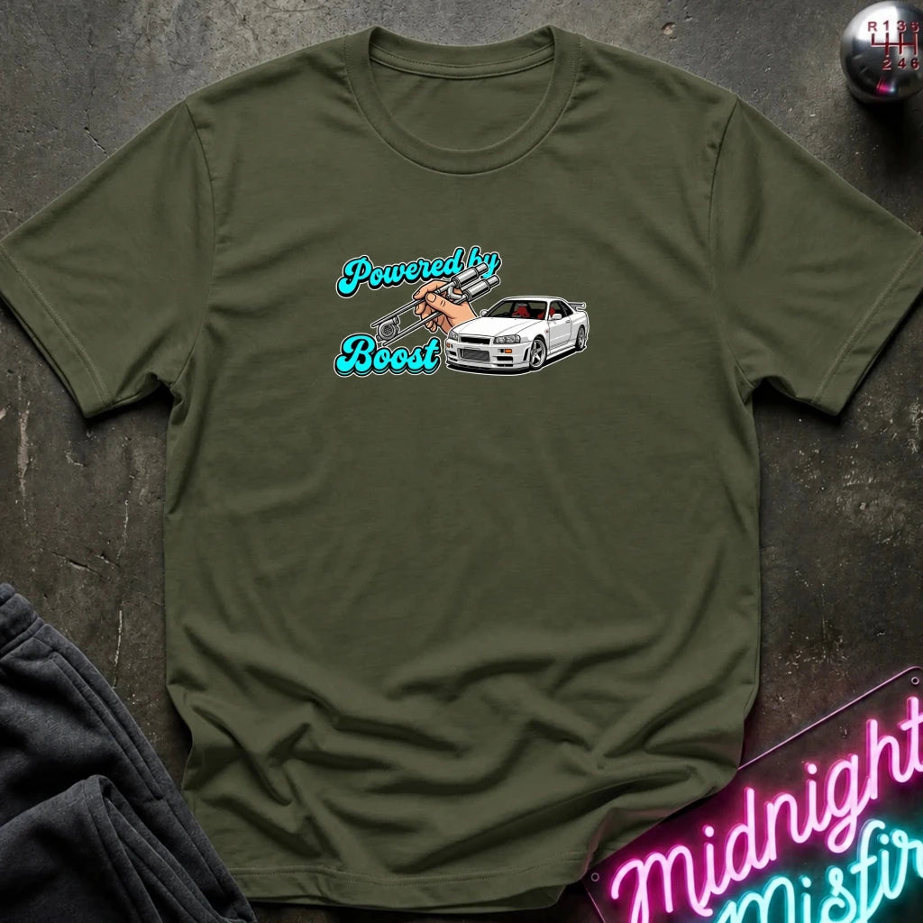 An olive green crewneck t-shirt laid flat on a dark textured surface. The shirt features a graphic print on the chest with the text 'Powered by Boost' in a stylized blue font, alongside an illustration of a white sports cae