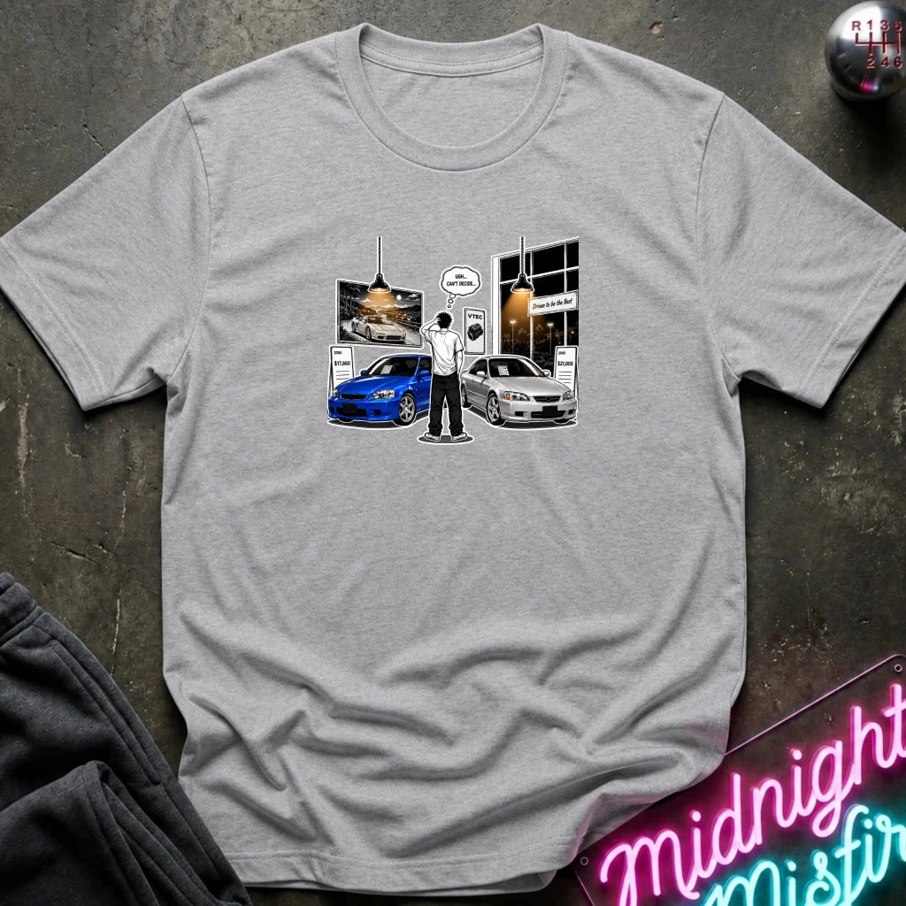 A heather gray short-sleeve crewneck t-shirt laid flat on a dark textured surface. The center of the shirt features a graphic print depicting a scene with a blue and silver  sports cars