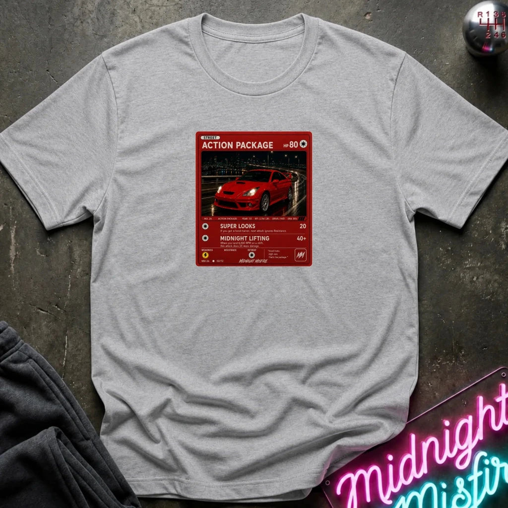 grey crewneck t-shirt laid flat on a dark textured surface, featuring a red graphic print vintage card and a car.