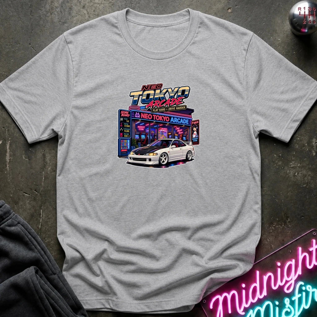 A light gray heather crewneck t-shirt featuring a colorful 'Back to the Future' Neo Tokyo Arcade graphic with a white sports car, laid flat on a dark textured surface with a neon sign and sweatpants partially visible.