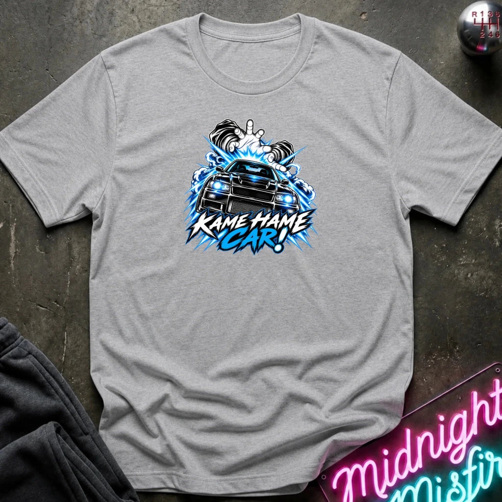 gray short-sleeve graphic t-shirt laid flat on a dark textured surface. The shirt features a red, white, and black graphic of a car with the text 'KAME HAME CAR!' in stylized lettering.