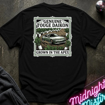 A black short-sleeve graphic T-shirt laid flat on a dark textured surface. The shirt features a rectangular vintage-style print with the words 'Genuine Touge Daikon' and 'Grown in the Apex' surrounding an illustration of a green car in a field.