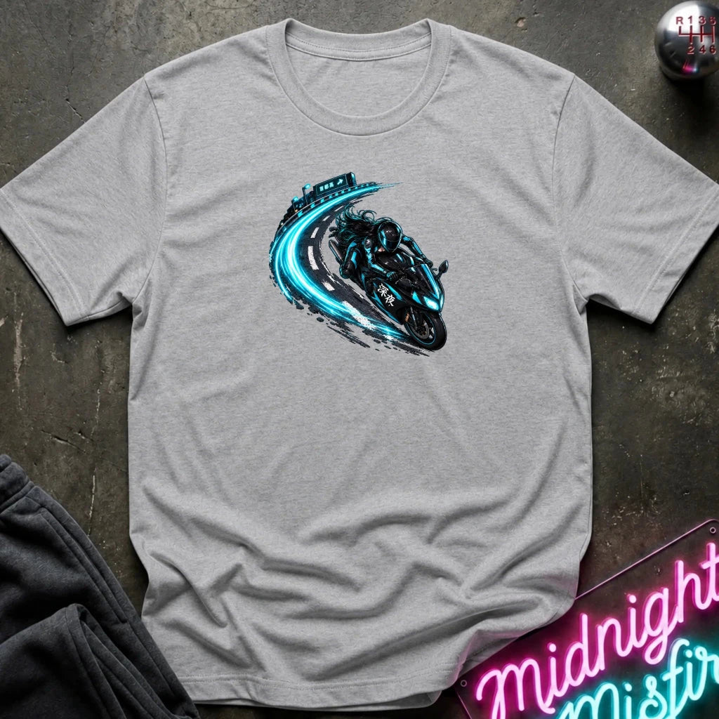 A light heather gray short-sleeve t-shirt laid flat on a dark textured surface, featuring a graphic print of a black motorcycle with glowing blue neon-style trails