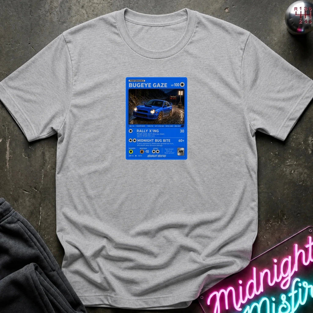 grey crewneck t-shirt laid flat on a dark textured surface, featuring a graphic print of vintage card and a car.