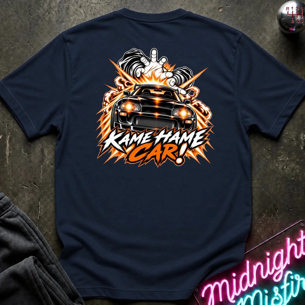 A navy blue t-shirt laid flat on a dark textured surface, featuring a large back graphic of a black muscle car surrounded by flames and the text 'KAME HAME CAR!'.
