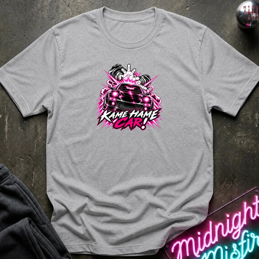gray short-sleeve graphic t-shirt laid flat on a dark textured surface. The shirt features a red, white, and black graphic of a car with the text 'KAME HAME CAR!' in stylized lettering.