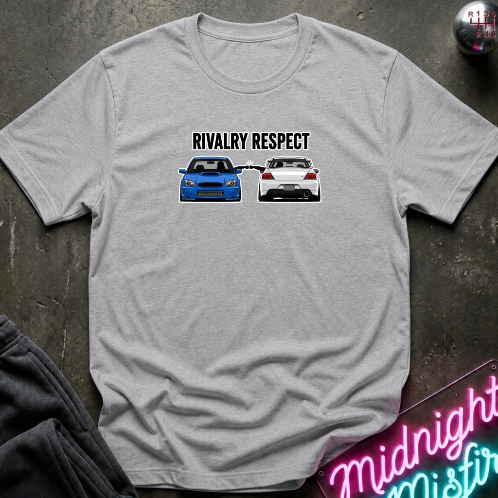 grey graphic t-shirt laid flat on a dark textured surface. The graphic features the text 'RIVALRY RESPECT' above a blue car facing a white car.