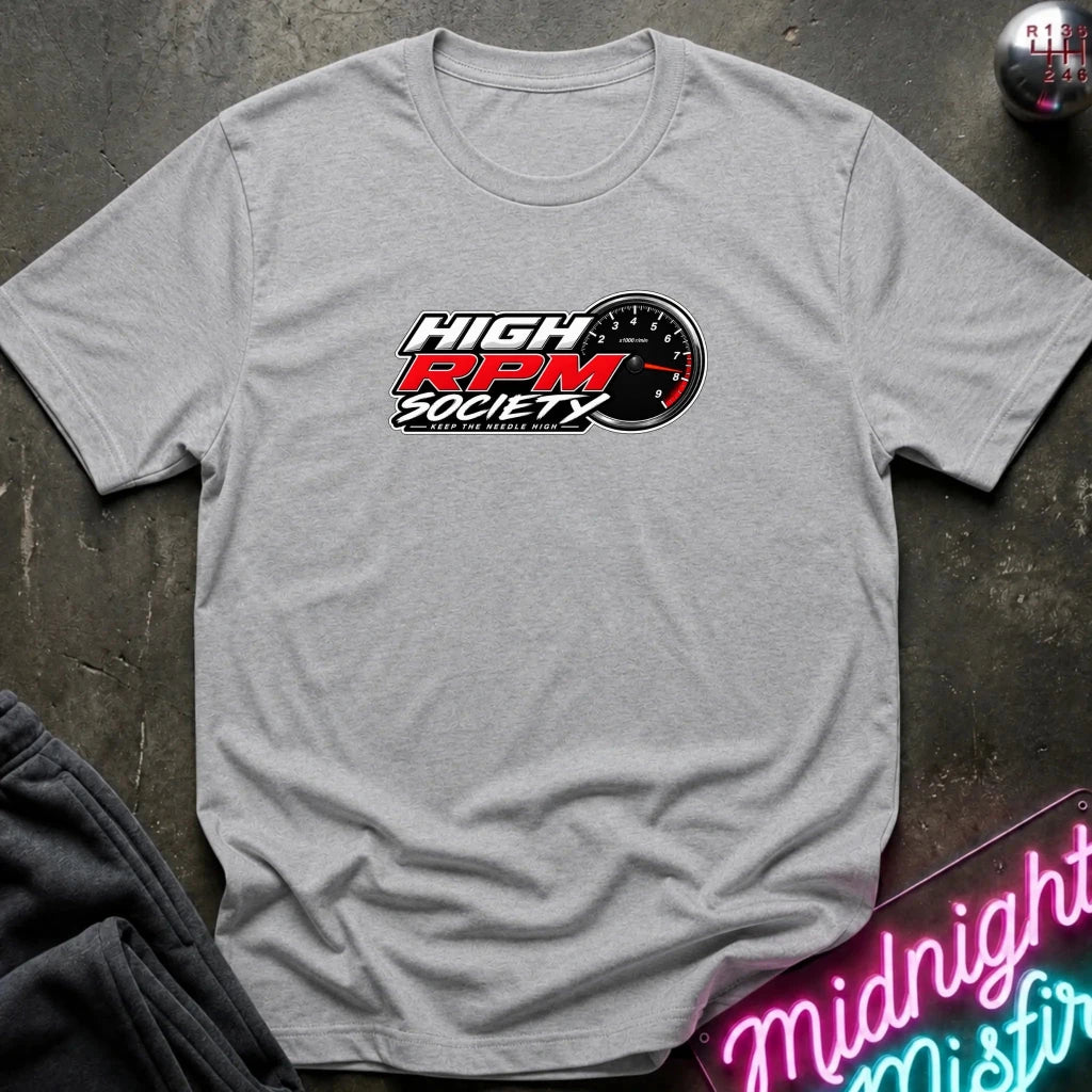 A heather gray short-sleeve t-shirt laid flat on a dark textured surface, featuring a 'High RPM Society' graphic on the chest with a red, white, and black design.