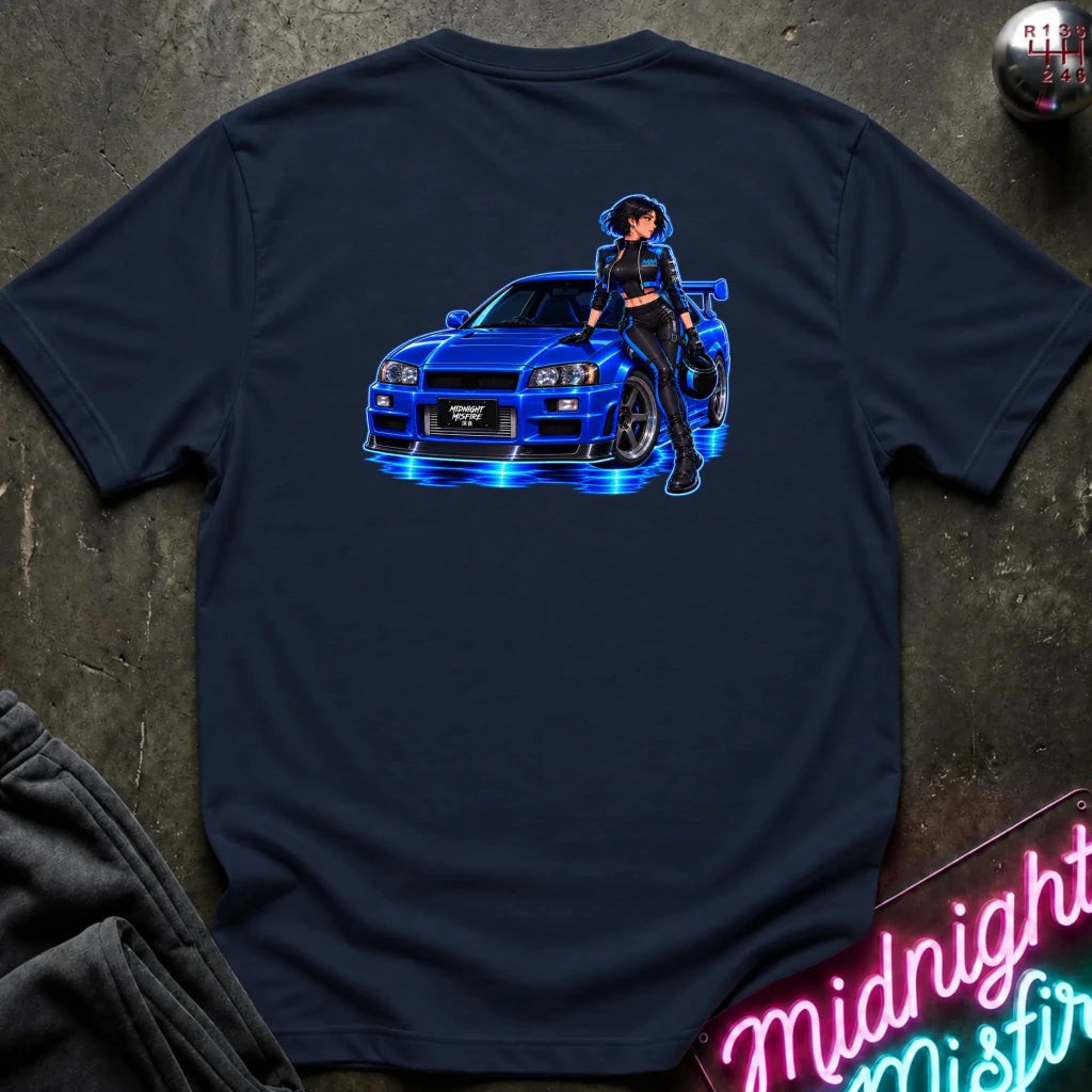 A navy blue short-sleeve t-shirt laid flat on a dark textured surface, featuring a graphic print of a blue sports car with glowing blue lights and an anime-style woman standing beside it. 