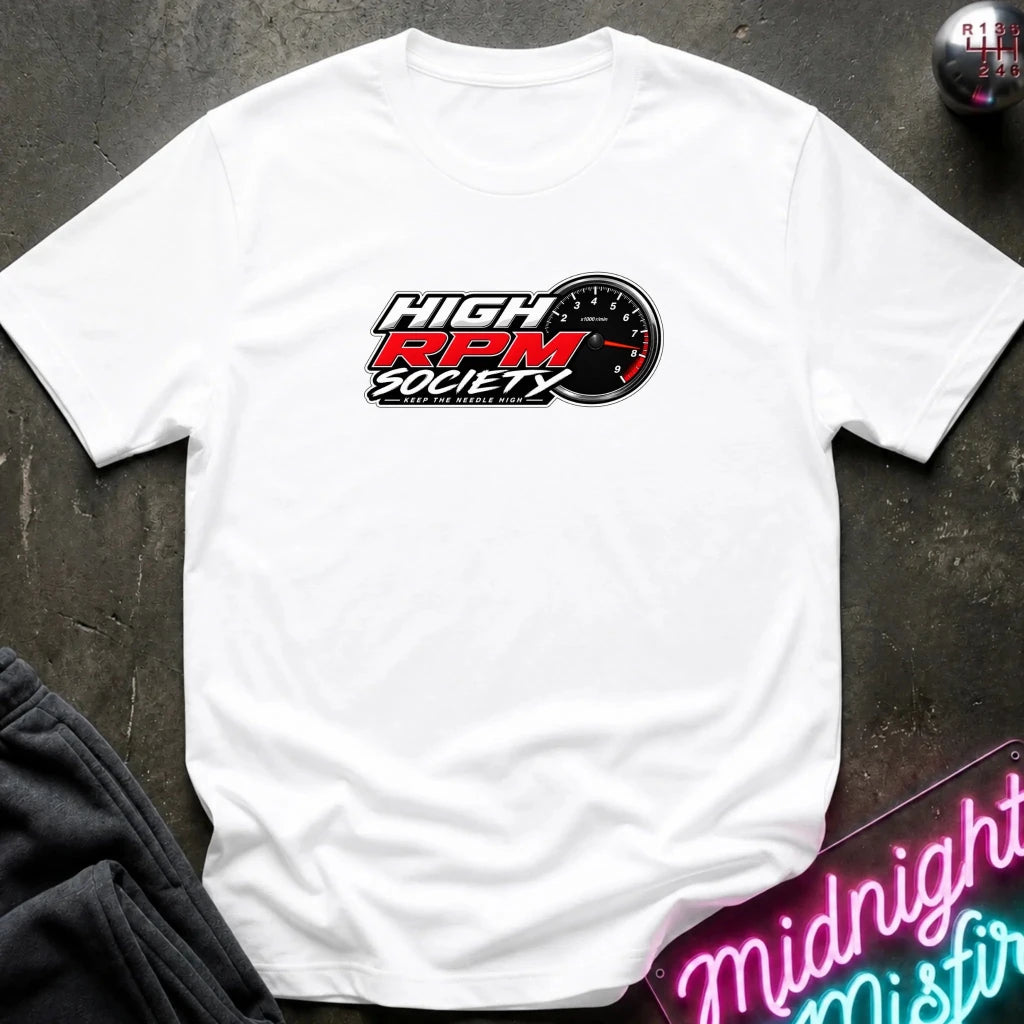 A white short-sleeve t-shirt laid flat on a dark textured surface, featuring a 'High RPM Society' logo printed on the chest with a black and red design. 