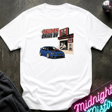 A white short-sleeve graphic t-shirt laid flat on a dark textured surface. The graphic features a blue sports car and a retro-style diner sign with the text 'GYUDON DRIVE BY'.
