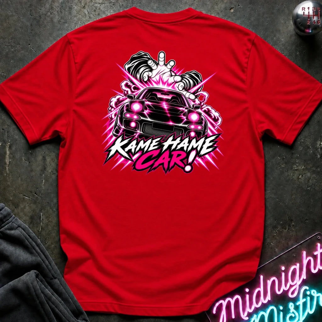 red short-sleeve t-shirt laid flat on a dark textured surface, featuring a large graphic print of a black sports car with  the text 'KAME HAME CAR!' 