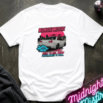 A white short-sleeve graphic t-shirt laid flat on a dark textured surface. The graphic features a silver car against a pink background with the text 'MIDNIGHTMISFIRE' 