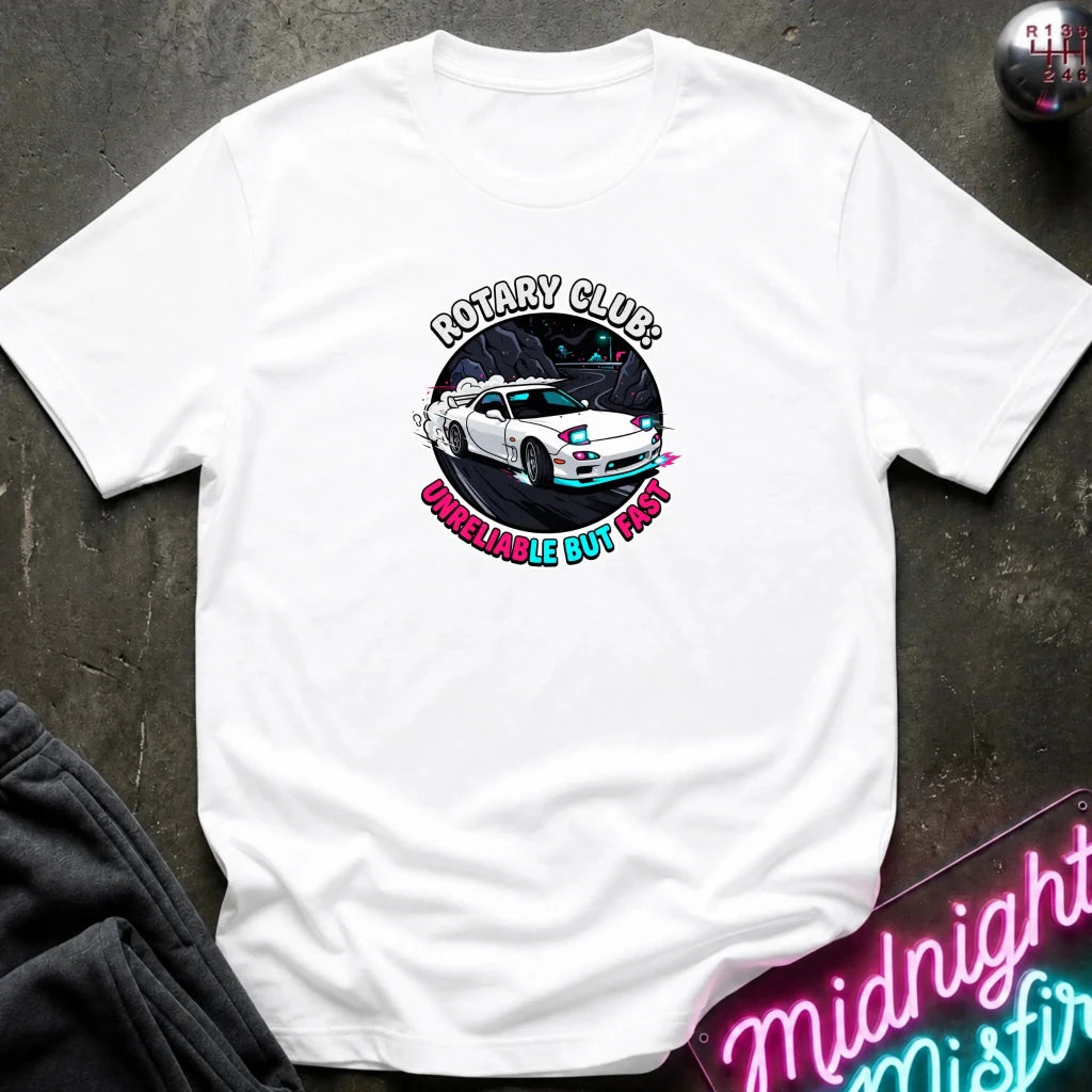 white crewneck t-shirt laid flat on a dark textured surface. The shirt features a circular graphic print in the center showing a white sports car with blue and pink accents, surrounded by the text 'ROTARY CLUB!