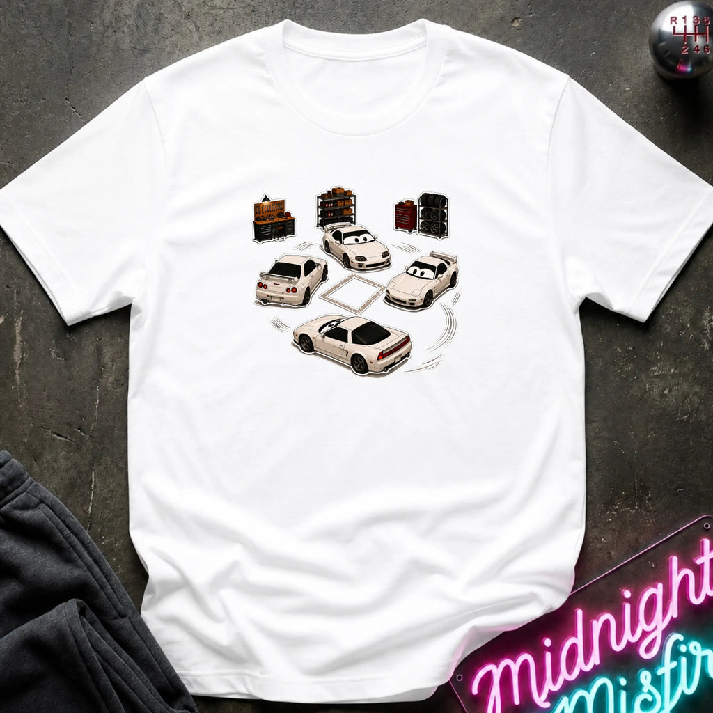 A white short-sleeve t-shirt laid flat on a dark textured surface, featuring a graphic print of several white sports cars arranged in a circle with drift-like tire marks.
