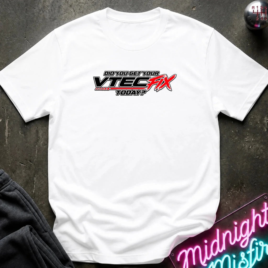 A white short-sleeve t-shirt laid flat on a dark textured surface, featuring a red and black 'VTEC FIX' graphic with the text 'DID YOU GET YOUR VTEC FIX TODAY?' across the chest.