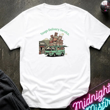 A white short-sleeve t-shirt laid flat on a dark textured surface, featuring a colorful graphic of a green van carrying stacked boxes with the text 'Touge Delivery Service.' printed above it.