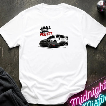 A white short-sleeve graphic t-shirt laid flat on a dark textured surface. The graphic features the text 'SMALL.