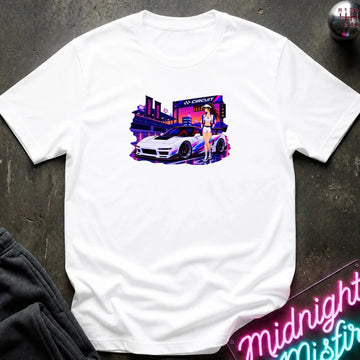 A white short-sleeve crewneck t-shirt laid flat on a dark textured surface, featuring a colorful graphic print of a white sports car in front of a neon-lit cityscape with a woman standing beside it.