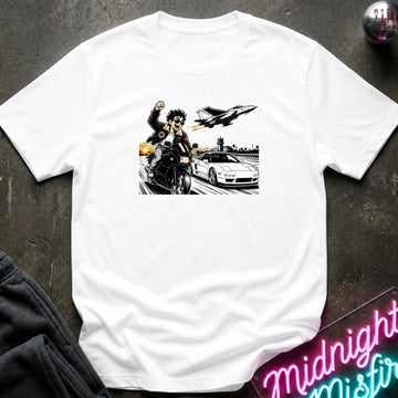A white short-sleeve crewneck t-shirt laid flat on a dark textured surface, featuring a black and white graphic print of a motorcycle racer, a sports car, and a jet plane.
