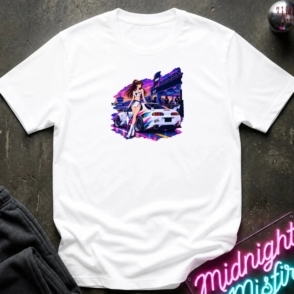 A white  short-sleeve t-shirt laid flat on a dark textured surface, featuring a colorful graphic print of a white sports car and a woman in a neon-lit scene. 