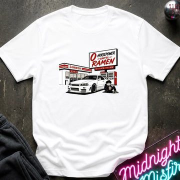A white short-sleeve graphic T-shirt laid flat on a dark textured surface. The shirt features a printed illustration of a white sports car parked front of a store.
