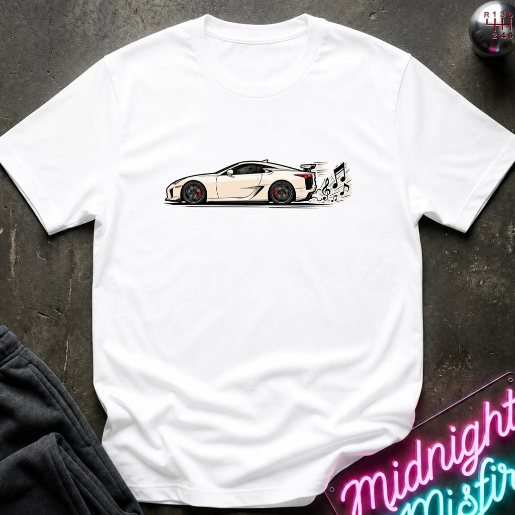 A white short-sleeve t-shirt laid flat on a dark textured surface, featuring a graphic print of a white sports car with a music note coming from exhaust.