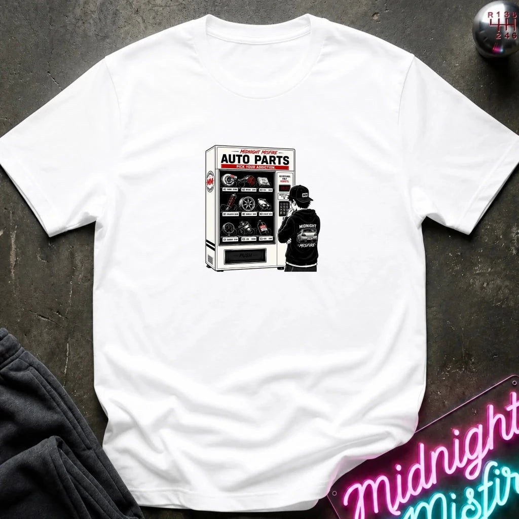 A white short sleeved t-shirt featuring a person in front of a vending machine  with car parts.