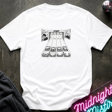 white crewneck t-shirt featuring a black and white graphic print of 4 cars lined up at a race starting line with the word 'START' above them. The shirt is laid flat on a dark textured surface with a neon sign and dark pants partially visible in the corners.