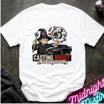 A white short-sleeve graphic T-shirt laid flat on a dark textured surface. The shirt features a colorful cartoon wizard holding a wand next to a black sports car, with the text 'CASTING BOOST' and smaller text below.