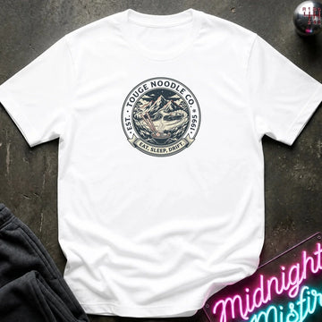 A white short-sleeve crewneck t-shirt laid flat on a dark textured surface. The center of the shirt features a circular graphic print with a noodle bowl illustration and the text 'TOUGE NOODLE CO' 