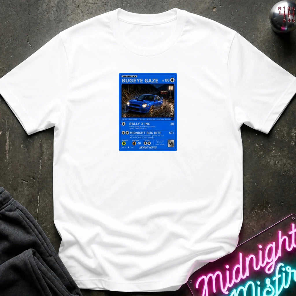 white crewneck t-shirt laid flat on a dark textured surface, featuring a graphic print of vintage card and a car.
