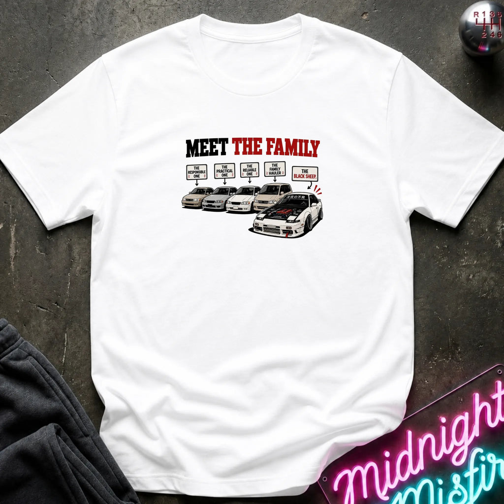 A white short-sleeved t-shirt  that has a cars parked with one standing out that says black sheep.