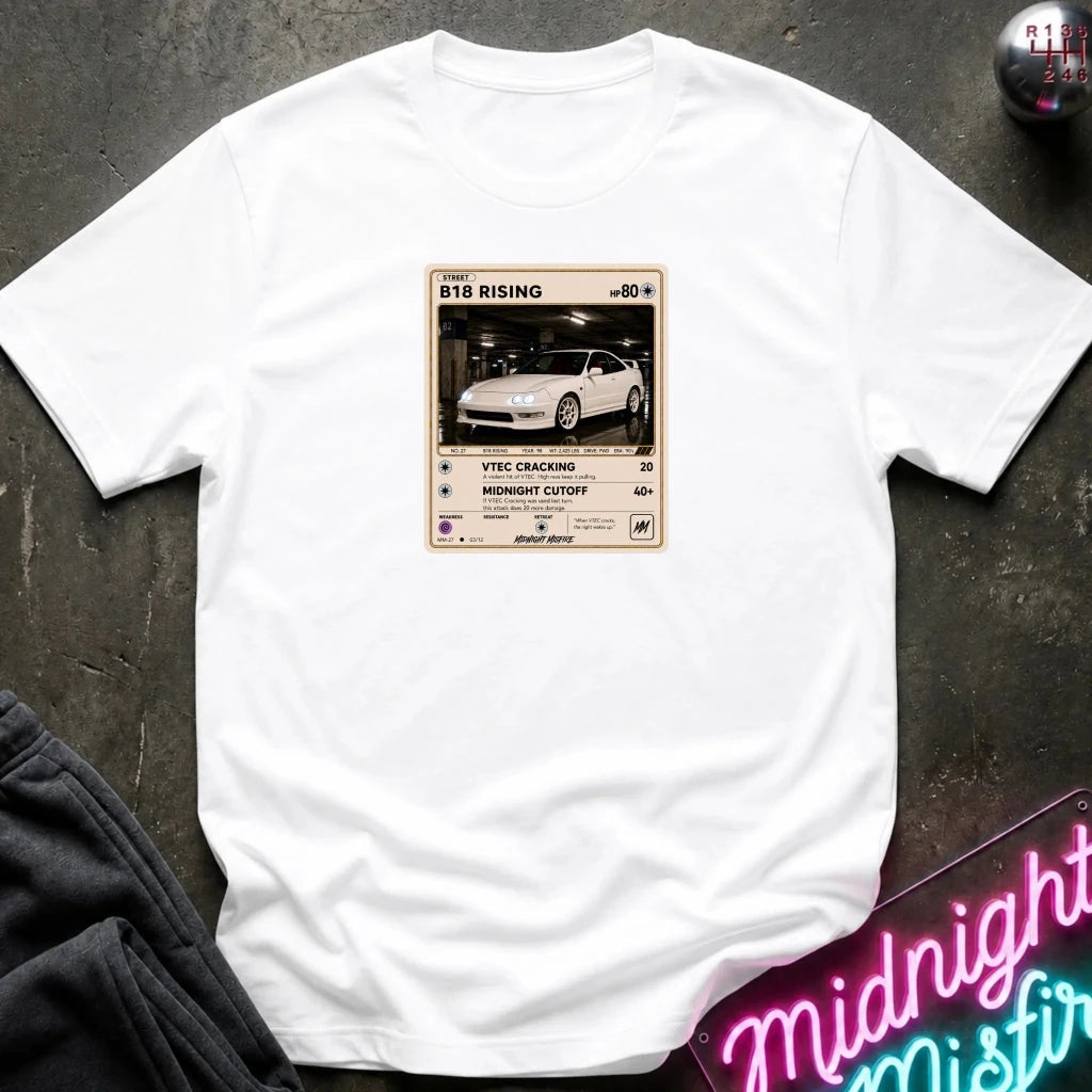 white crewneck t-shirt laid flat on a dark textured surface. The shirt features a graphic print styled like a retro card