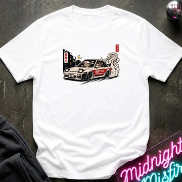 A white short-sleeve t-shirt with a graphic print of a drifting car, laid flat on a dark textured surface with a neon sign and dark pants partially visible.