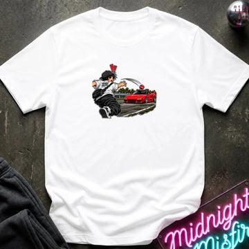 A white short-sleeve crewneck t-shirt laid flat on a dark textured surface. The center of the shirt features a graphic print of an anime character in a black and white outfit with a hat, next to a sports car 