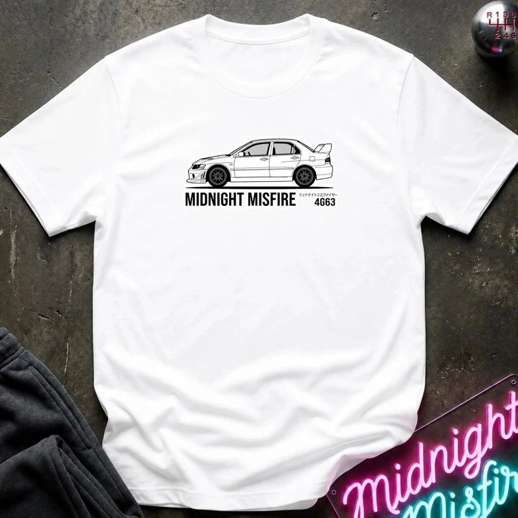 white short-sleeve t-shirt laid flat on a dark textured surface, featuring a white sports car graphic and the text 'MIDNIGHT MISFIRE '