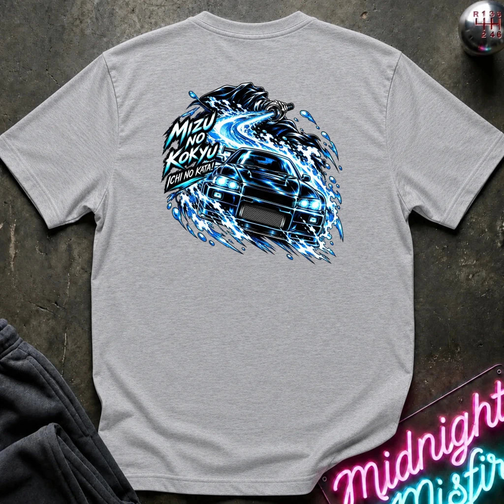 A light gray heather short-sleeve t-shirt laid flat on a dark textured surface, showing the back graphic with a car and the text "ichi no kata!"