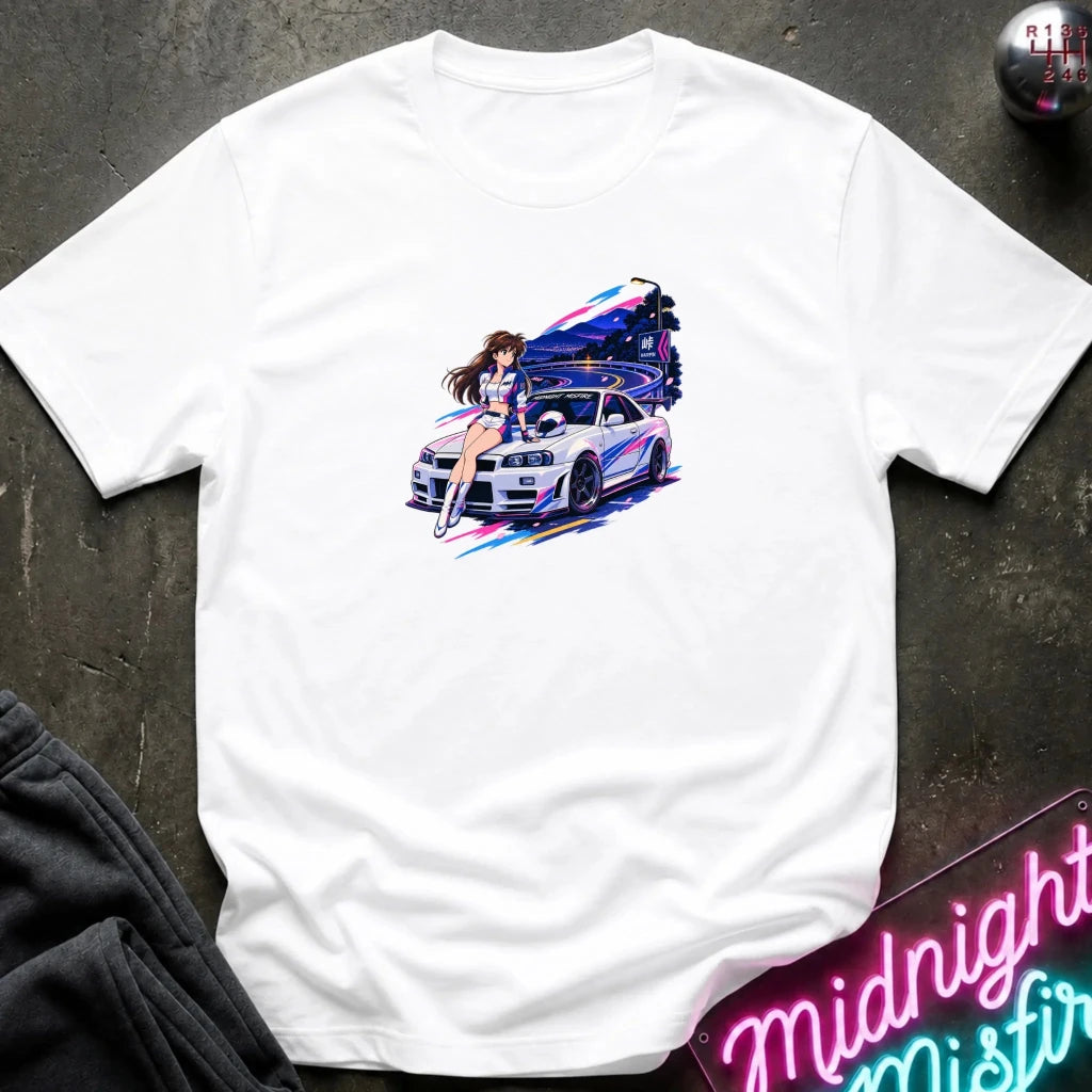 A white  short-sleeve t-shirt laid flat on a dark textured surface, featuring a colorful graphic print of a white sports car and a woman in a neon-lit scene. 