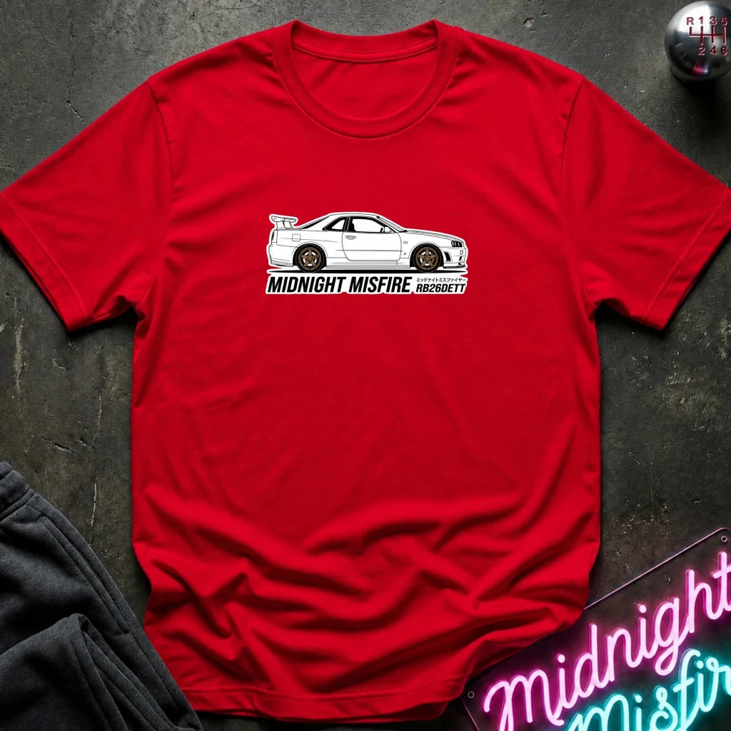 red short-sleeve t-shirt laid flat on a dark textured surface, featuring a white sports car graphic and the text 'MIDNIGHT MISFIRE '